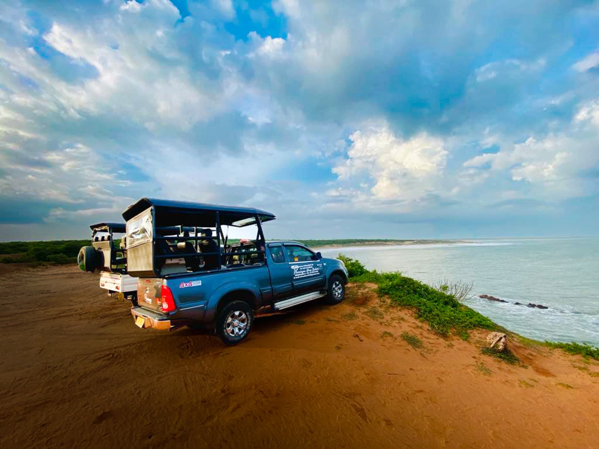 Safari jeep travelling beside a peaceful Sri Lankan lagoon